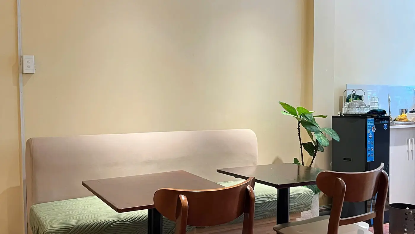 The olive banquette and tables at Virgin Saigon Original Coffee, six minutes from Bến Thành station.