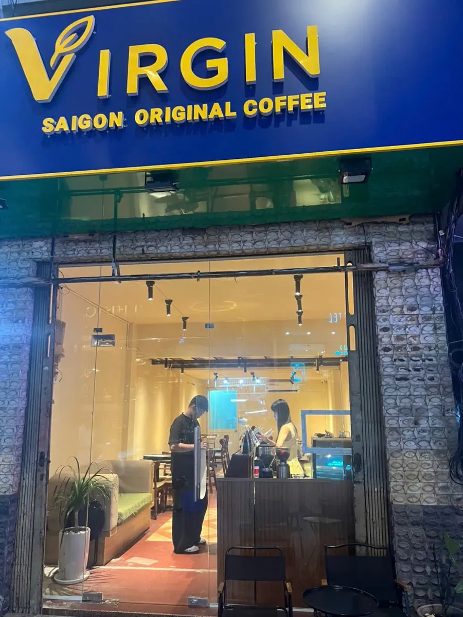 The lit Virgin sign over the open shopfront at 42 Nguyễn Thái Bình at night, one block in from Nguyễn Huệ.