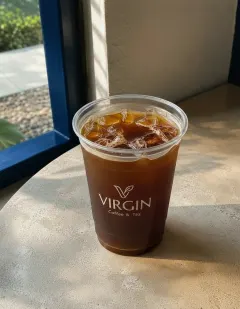 Iced Americano in the Virgin cup, clear dark coffee over ice with a thin crema at the surface.
