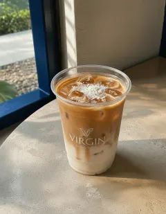 Iced Americano with coconut milk in the Virgin cup, coconut marbling swirling through the coffee.