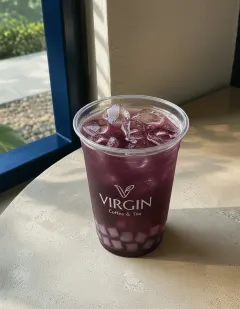Iced black grape tea with aloe vera in the Virgin cup, deep jewel-toned purple tea with translucent aloe vera cubes.
