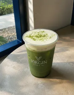 Iced cheese matcha in the Virgin cup, matcha base under a dense ivory cheese-cream cap with a visible boundary.
