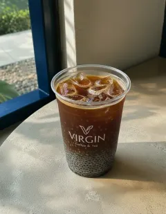 Cold brew coffee with chia seeds in the Virgin cup, dark coffee over ice with chia seeds settled at the base.