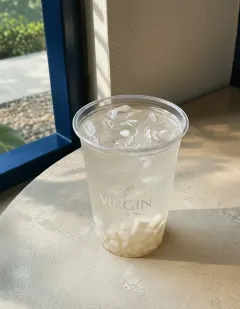 Fresh coconut water with water chestnut in the Virgin cup, near-clear pale coconut water with translucent chestnut cubes.