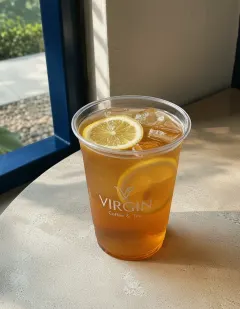 Iced honey lemon tea in the Virgin cup, clear honey-amber tea over ice with lemon slices.