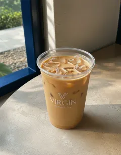 Iced latte in a clear ribbed cup with the Virgin logo, uniform tan colour with a thin layer of foam.
